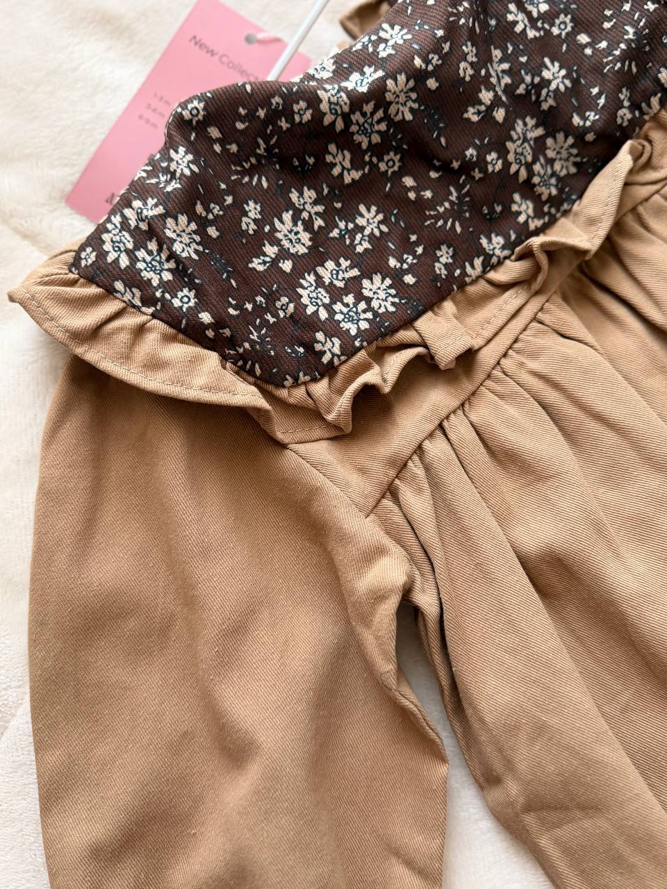 Brown baby romper with a floral print and collar